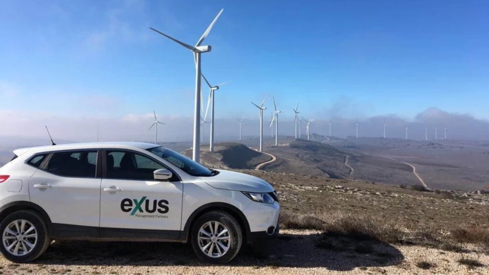 Exus Renewables Car in front of wind turbine Exus Renewables Car in front of wind turbine